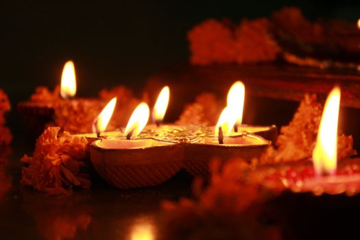 Earthen oil lamps lit with flowers during the performance of a hindu ritual.