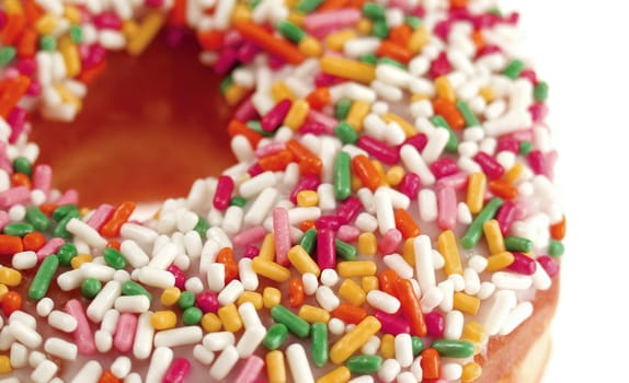 Pink Iced Doughnut covered in sprinkles isolated