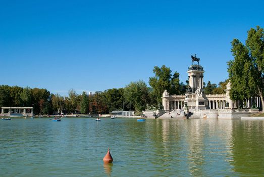 Large lake with boats and antique statues in the park, Madrid