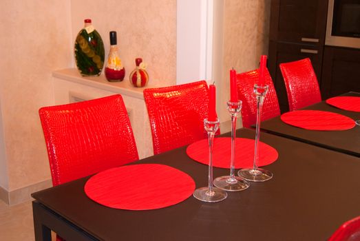Red chairs and spark candles on brown table. the interior of dinner room