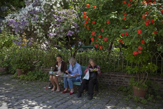 LUNCH BREAK IN THE PARK, PARIS, FRANCE - APRIL 21, 2011: Three women enjoying their lunch break in a Parisian park at springtime.