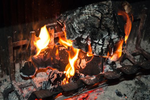 Burning wood with flames in household fireplace