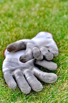 Dirty gardening gloves on the grass