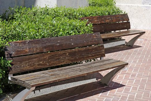 Two empty wooden benches near church in Lloret de Mar.