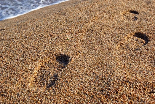 Foot prints on the mediterranean beach. Sunset time. As backdrop or background.