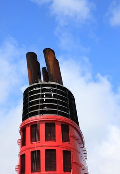 Chimney of big cruise ship and blue sky in background.