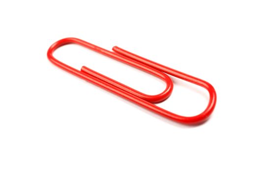 Macro of red paper clip isolated on white background.