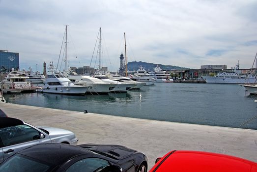 Cars and yachts in spanish Barcelona harbor.