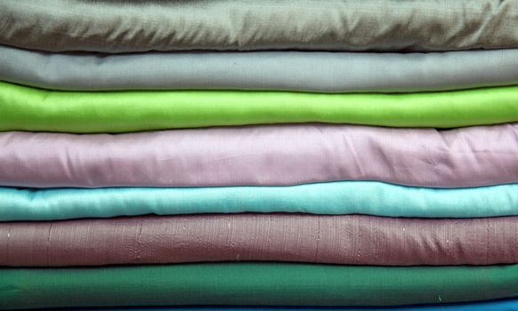stack of colorful praewa silk fabric cloth using as background