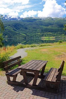 Picnic table and benches near lake in Norway, Europe.