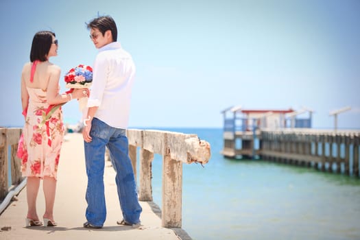 couples make eye contact at pier on the beach