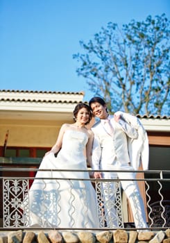 portrait of lovely bride and groom standing over mediterranean building