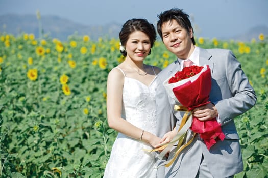 portrait of bride and groom on sunflower field