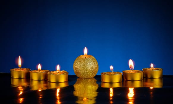 Seven burning candles over blue background