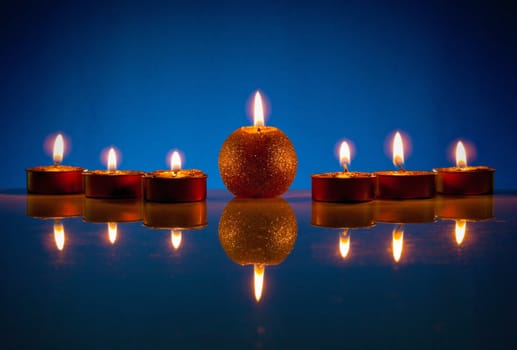 Seven burning candles over blue background