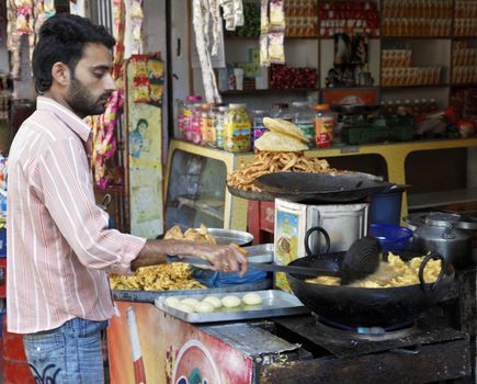 Jammu Kashmir, India - December 18, 2011: Portrait of a cook frying pakoras at a fast food and snack stall in Jammu Kashmir the Northern regions of India
