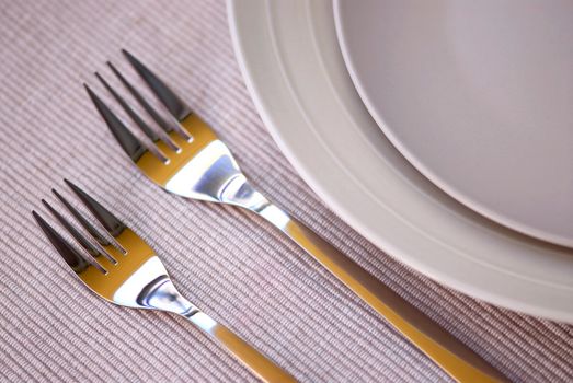 Dinner place setting with plates and cutlery shallow dof