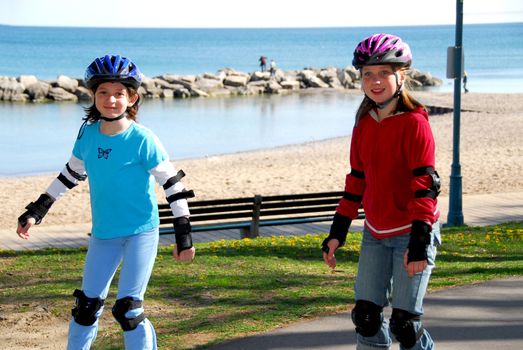 Two girls rollerblading on lake shore trail