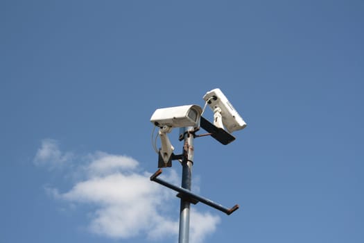 security camera's on pole against a blue sky