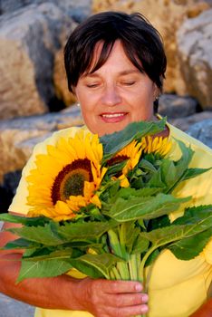Mature woman with bouquet of sunflowers