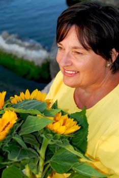 Mature woman with bouquet of sunflowers