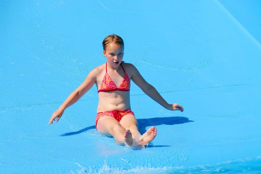 Young girl goind down water slide