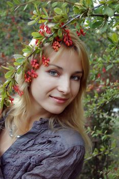 Pretty girl touching barberries and smiling