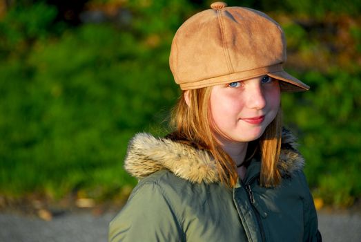 Portriat of a young smiling girl in winter or fall clothes outside