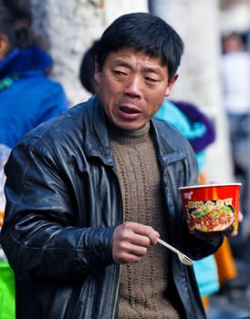 Chinese man eating in Shanghai street