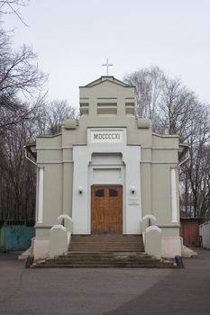 Small freshly painted Lutheran chapel on Vvedenskoe cemetery in Moscow on overcast winter day