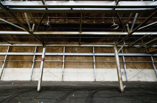 Interior of an empty and abandoned industrial building with exposed girders.