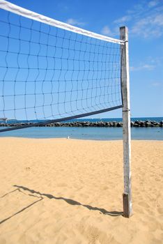 Beach volleyball net in perspective on a sandy beach