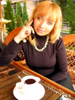 girl sitting in cafe and talking on the phone