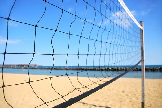 Beach volleyball net in perspective on a sandy beach