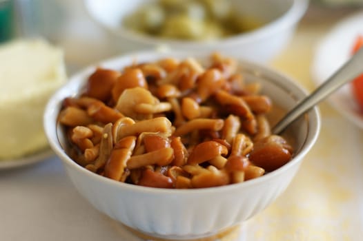 The pickled mushrooms are in a white dish