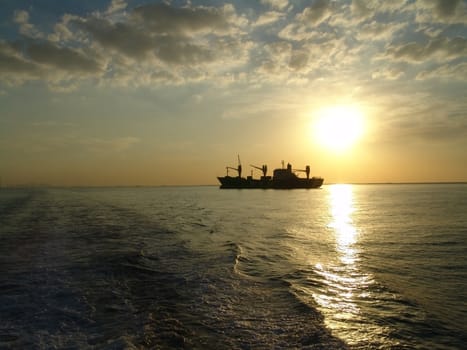 Siluet of ship on a background sunset in a bay                               