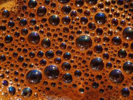 Bubbles and froth on the surface of a fresh brewed pot of pressed coffee.