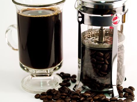 Coffee Beans, a Cup of Brewed Coffee and a Coffee Press