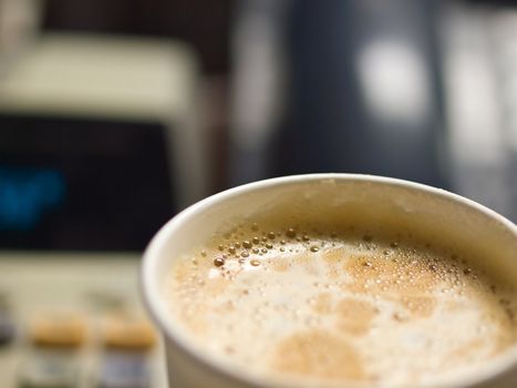 Cup of Coffee in a Paper Cup on a Office Desk