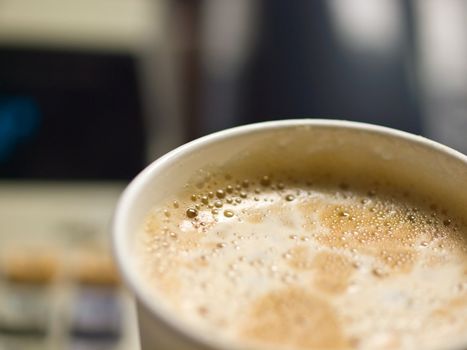 Cup of Coffee in a Paper Cup on a Office Desk