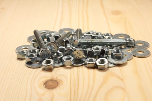 Bolts, nuts and plates on wood table