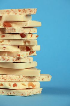 Slabs of assorted delightful white chocolate goodness stacked on top of each other over a blue background.