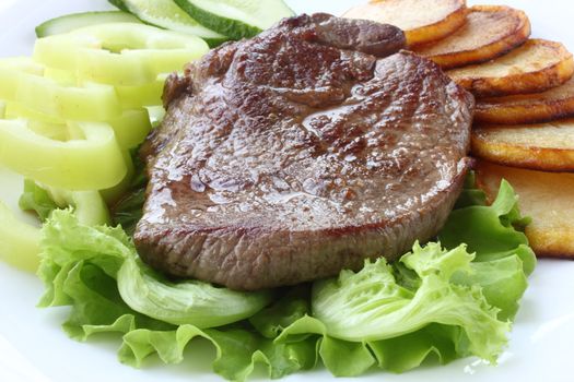 Roasted meat with fried potatoes and fresh vegetables