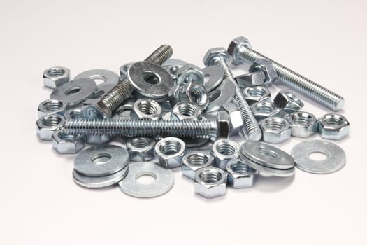 Bolts, nuts and plates on white background