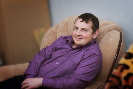 Portrait of a smiling young man in a chair