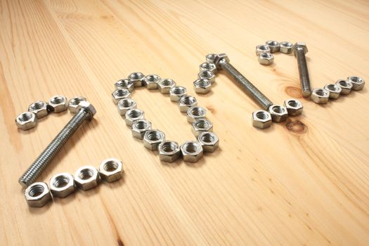 Digits 2012 of bolts and nuts on wood table