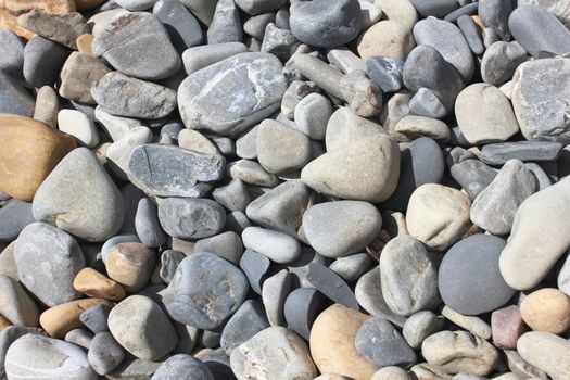 Pebbles on sea coast, pebble background.
