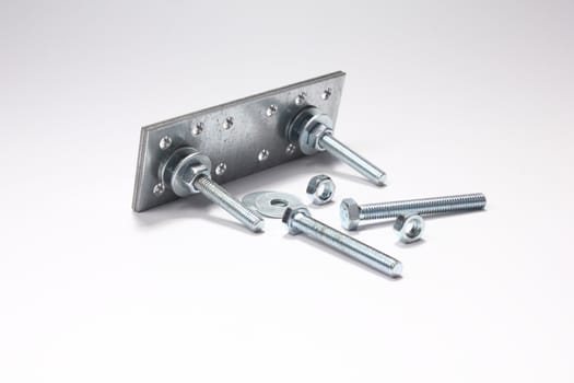 Construction of bolts, nuts, washers and plates on white background.