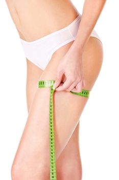 Measure tape around slim woman's leg, isolated on white. Health concept