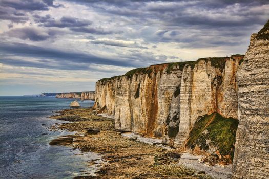 Specific cliffs in Etretat in the Upper-Normandy region in Northern France, during the low tide time.